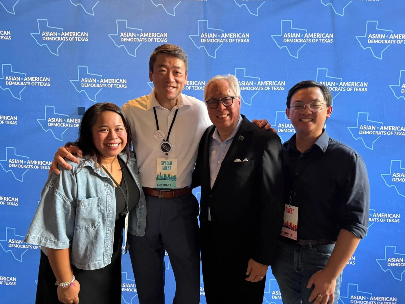 Four people posing together in front of a blue AADT backdrop.