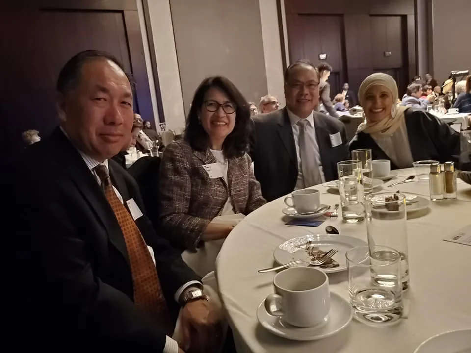 Four people seated together at a banquet table.